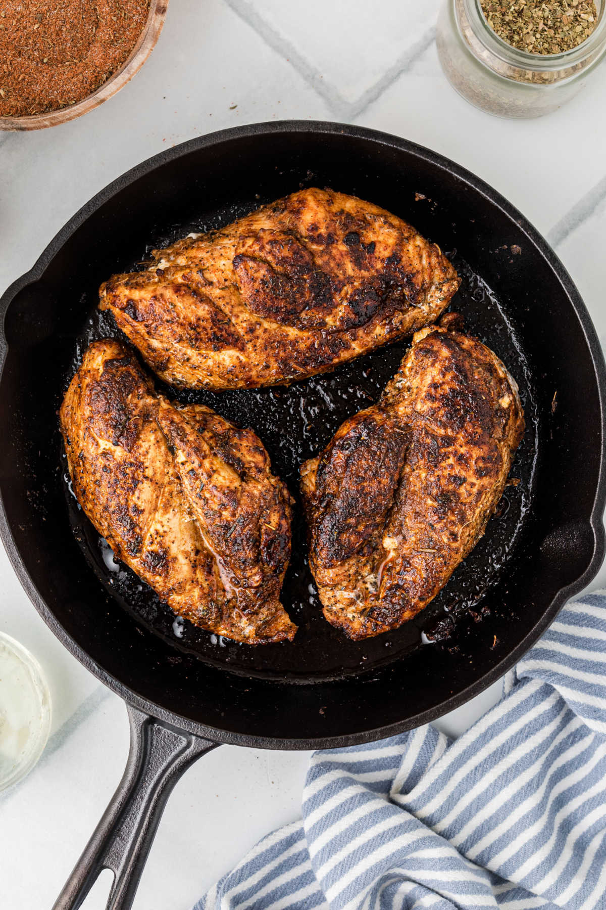 Cast iron skillet with some cooked blackened chicken.
